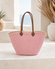 Back view of a handmade VVC soft pink sequin basket featuring brown leather handles, natural palm leaf construction and artisan craftsmanship. Large boho-style beach and shopping basket with approximately 100 litres carrying capacity.
