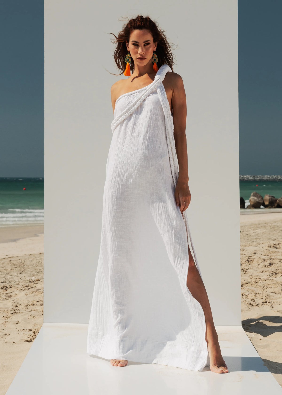 Front view of the VVC white one-shoulder maxi dress with handcrafted macramé shoulder
