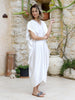 Woman wearing the VVC white kaftan dress in a relaxed front view, styled as elegant luxury resort wear in Sitia, Crete