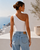 Back view of a white one-shoulder summer top showing the asymmetric shoulder design in a Mediterranean setting.