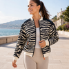 Front view of zebra activewear jacket by Kasha with orange zipper details, sporty fit and breathable lining, available at VVC Shop Sitia, Crete and online at www.viktoria-vigh.com.