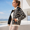 Side view of zebra activewear jacket with black breathable lining, orange zipper details and sporty styling, available at VVC Shop Sitia, Crete and online at www.viktoria-vigh.com.
