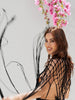 Back view of the Zoe black macramé cover-up with a straight loose fit and transparent crochet design.