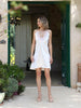 Front-angle view of the ZOE white Feather short wedding dress showing the feather-trimmed neckline and short A-line silhouette, made in Greece.