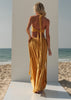 Full-length back view of the ZOE Zena mustard-yellow set showing its braided halter ties and flowing low-waist maxi skirt.